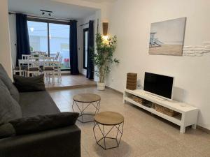 sala de estar con sofá y TV de pantalla plana en Urb Las Cañas Apartamento B3, en Tarifa
