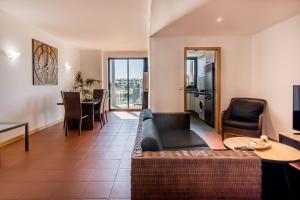 a living room with a couch and a table at Superbe appartement spacieux avec terrasse vue piscine in Vilamoura