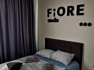 een slaapkamer met een bed en een bord met vuur bij FiORE self check-in in Osijek
