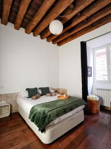 Un dormitorio con una cama con una manta verde. en El museo, en Ávila
