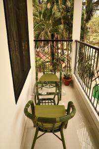 two green chairs sitting on a balcony at GRUHAM SOJOURN HOMESTAY in Guwahati