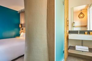 a hotel room with a bed and a sink at ibis Budget Paris Nord 18ème in Paris