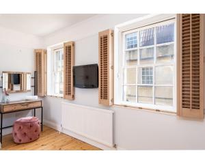 a room with two windows and a tv on the wall at Murphys House - 3 bed Luxury Central Townhouse in Bath