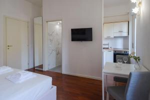 a white room with a kitchen and a table with a chair at Milanoverse Junior Apartment in Milan