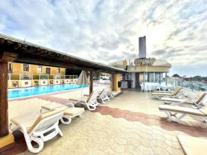 a group of lounge chairs and a pool on a building at Hotel Casa del Sol in Puerto de la Cruz