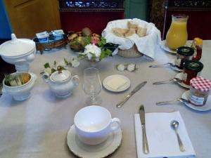 une table avec des assiettes, des tasses et des ustensiles dans l'établissement Propriété Charbaymond, à Clermont-Ferrand
