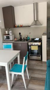 una cucina con tavolo bianco, tavolo e piano cottura di Costanera Aparts a Villa María