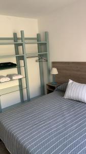 una camera da letto con un letto con una coperta blu e bianca di Costanera Aparts a Villa María Altre 18 foto