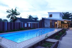 a swimming pool in front of a house at Badi's Place in Moalboal