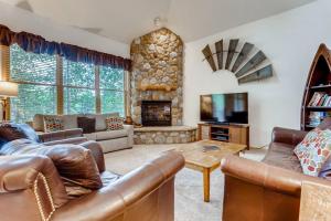 ein Wohnzimmer mit Ledermöbeln und einem Steinkamin in der Unterkunft Corral at Breckenridge 207S Heron Condo a Spacious Great Location in Breckenridge