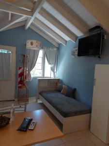 1 dormitorio con 1 cama y TV en la pared en Magda en Villa La Angostura