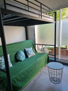 - un canapé vert dans une chambre avec une mezzanine dans l'établissement Studio Corniche, à La Ciotat