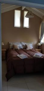 1 cama grande en un dormitorio con 2 ventanas en Magda, en Villa La Angostura