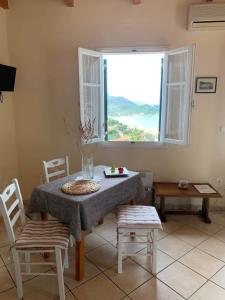 a dining room with a table and chairs and a window at Euktimeno in Vathi