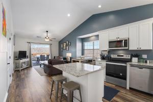 a kitchen and living room with white cabinets and a table at Eagle Nest Resort Pristine Dream in Branson