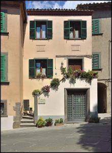 ein Gebäude mit grünen Fensterläden und einer Garage in der Unterkunft La Loggetta in Bagnoregio