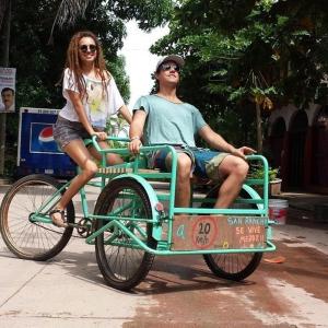 a man and a woman riding in a bike cart at Hostal San Pancho in San Francisco