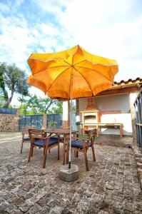 a wooden table with an umbrella on a patio at Casa das Vinhas Camélias de BastoTurismo Rural in Celorico de Basto