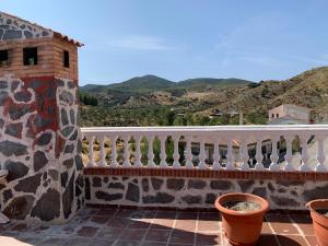 a balcony with a white railing and some plants at Monte Rosado viviendas vacacionales in Lapeza