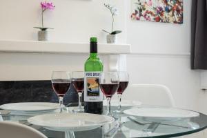 a bottle of wine and two glasses on a table at Barras House in Coventry