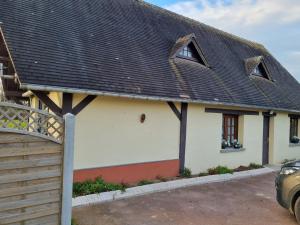 ein weißes Haus mit einem schwarzen Dach und einer Auffahrt in der Unterkunft Gîte côté albâtre in Thérouldeville