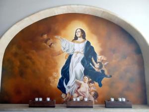 a painting of a woman in front of a wall at Casa de la Asunción in Oaxaca City