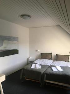 1 dormitorio con 2 camas y un cuadro en la pared en Roslev Hus en Roslev