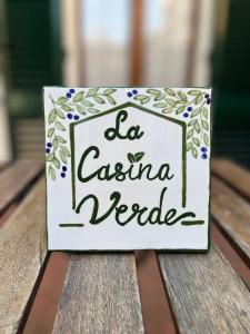 Znak, który czyta la easina verdes siedząc na stole w obiekcie La Casina Verde w Sienie