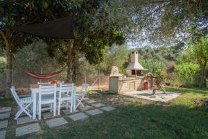 a table and chairs in a yard with a stove at Villa Varka in Vitalades