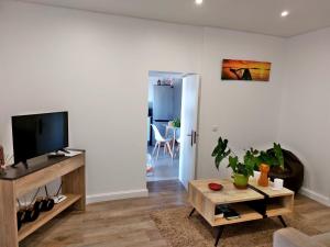 un soggiorno con tv e tavolo di Villa Nova Madeira in Funchal Casa A and B a Funchal