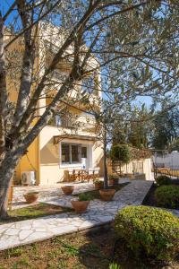 un edificio con un patio con algunas plantas y árboles en Julias Village-Allure, en Alepou