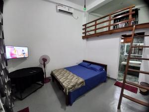a bedroom with a bed and a ladder and a fan at Star Guest in Balangoda