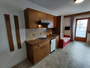 a kitchen with a sink and a red couch at Lärchenheim in Obereggen