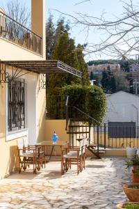 a patio with chairs and tables and a balcony at Julias Village-Allure in Alepou