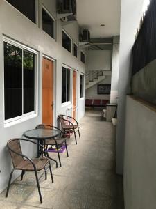 um grupo de cadeiras e uma mesa num quarto em 37 Guesthouse em Jakarta