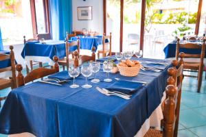 a table with a blue table cloth and wine glasses at Hotel Europa in Ischia
