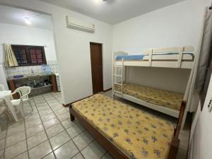 una camera con 2 letti a castello e una cucina di Chalés Mariah a Ubatuba