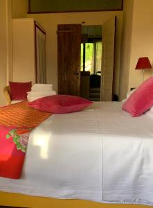 a bedroom with two beds with red pillows at Antico Borgo di Sugame in Greve in Chianti