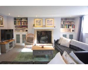 a living room with a couch and a fireplace at Hatfield Cottage in Bath