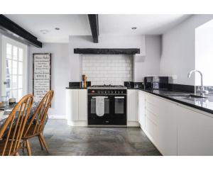a kitchen with a black oven and a table at Hatfield Cottage in Bath