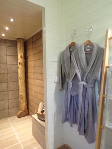 baño con albornoz colgado en la pared en La Maison du Potager, en Saint-Racho