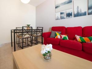 a living room with a red couch and a table at La Pituca in Playa Blanca