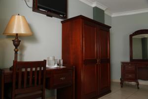 ein Zimmer mit einem Holzschrank und einem Schreibtisch mit Lampe in der Unterkunft Hotel Florencia in San Miguel
