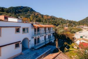 ariaal uitzicht op een huis met bergen op de achtergrond bij Corfu Star Apartments in Benitses