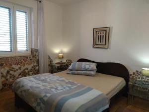 ein kleines Schlafzimmer mit einem Bett und einem Fenster in der Unterkunft Apartments Maja i Mate in Sućuraj