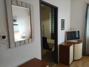 a room with a mirror and a desk with a television at Apartments Maja i Mate in Sućuraj
