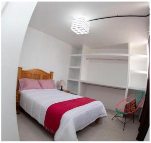 a bedroom with a bed with a red and white blanket at Hostel St Llorenc in Mexico City