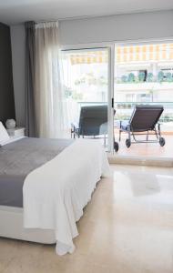 - une chambre avec un lit, un bureau et une chaise dans l'établissement Moderno Apartamento en Guadalmina Golf - Marbella, à Marbella