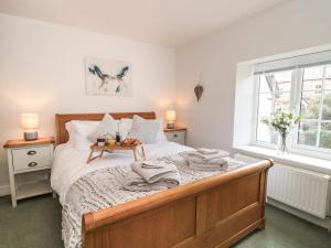 1 dormitorio con 1 cama con toallas en Jasmine Cottage, en Axminster