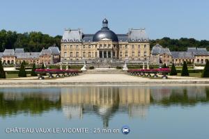 un gran edificio con un reflejo en el agua en Logement Noah en Evry-Courcouronnes